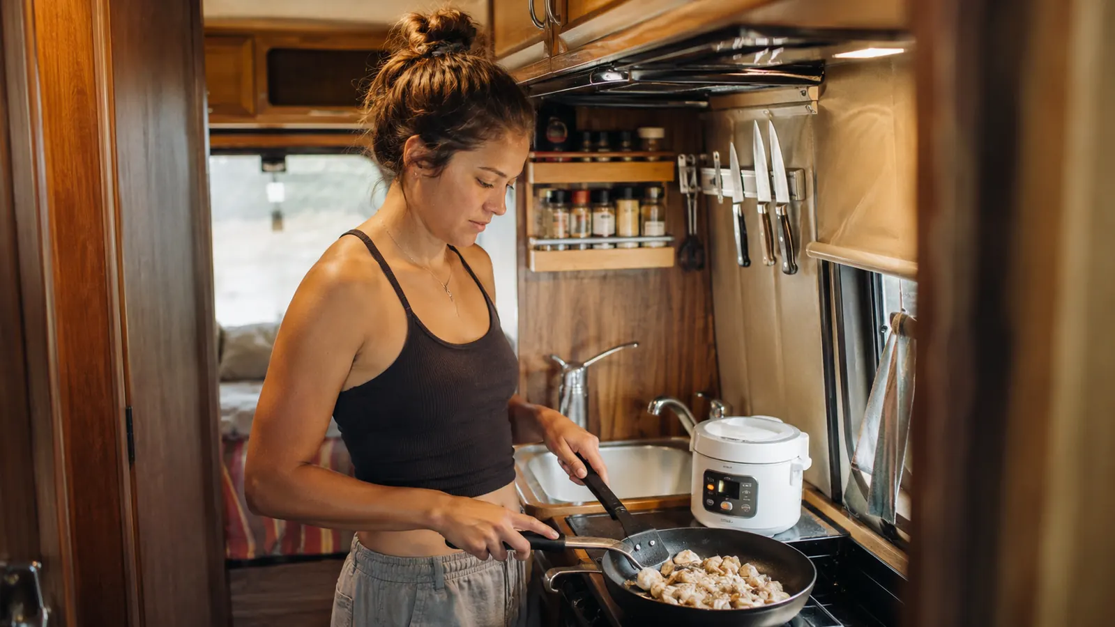 Dash Mini Rice Cooker packed inside a dorm room kitchenette alongside a small kettle and a mug